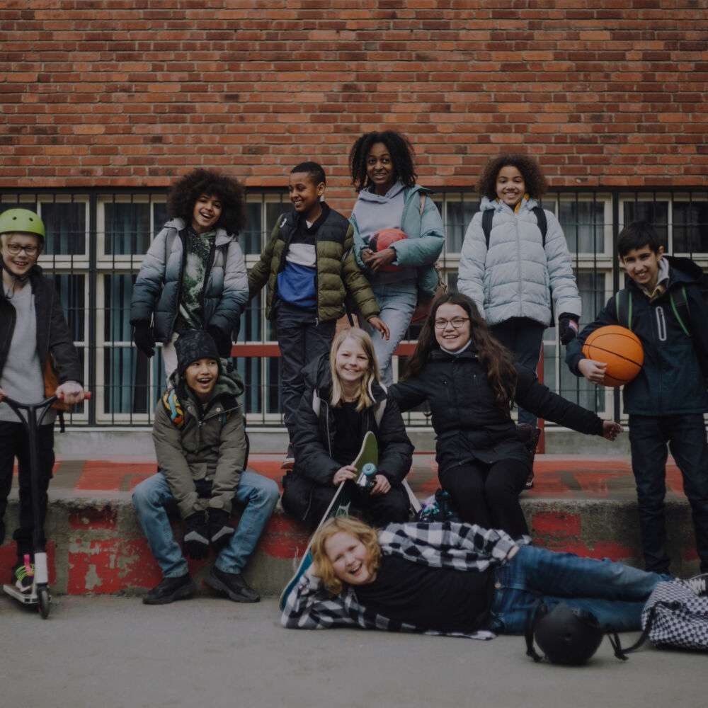 Porträtt av glada elever som leker under rast och fått veta vad klassens förtjänst är på en försäljning via klasskontot