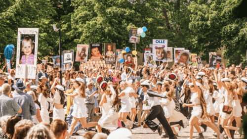 Studenter som springer ut på studentdagen med stydentskyltar.