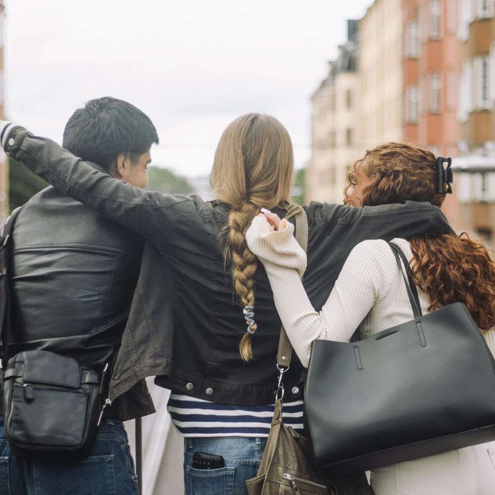 Samarbete mellan tonårsvänner som håller om varann och kollar ut från bro