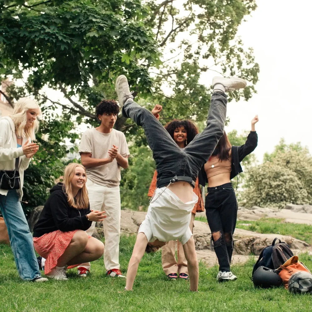 Klass som applåderar åt en klasskamrat som hjular och firar att de har tjänat pengar till klassen