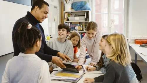 elever samlade runt ett bord och pratar med deras klassförälder om vad en klassförälder gör för något.