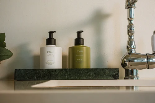 Paket av handtvål och handkräm från Foam i en köksmiljö.