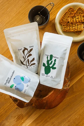 Paket med alla tre smaker av te från guldkoppen, liggandes på ett köksbord.