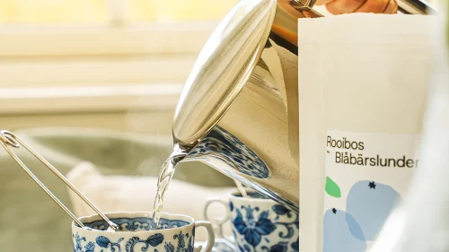 en person som häller upp te som de köpt via en klassförsäljning från klasskontot