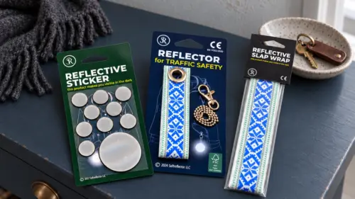 Reflexpaket Familj med reflexklistermärken, hängande reflex och slap wrap-band på en mörkblå hallbyrå.
